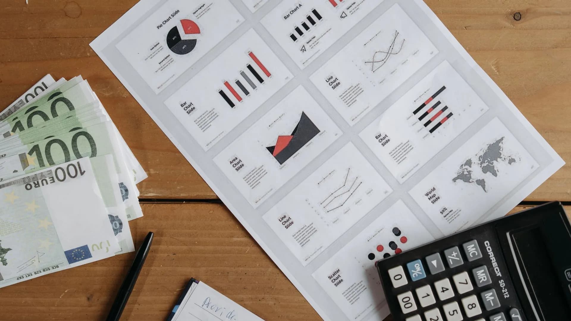 Euro banknotes, graphs, and calculator on a wooden table setup for financial analysis.