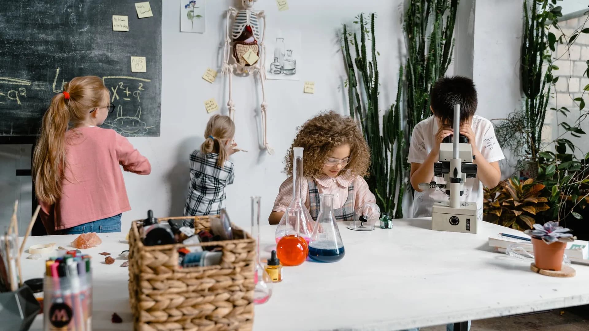 Curious children conducting science experiments in a classroom with flasks and a microscope.