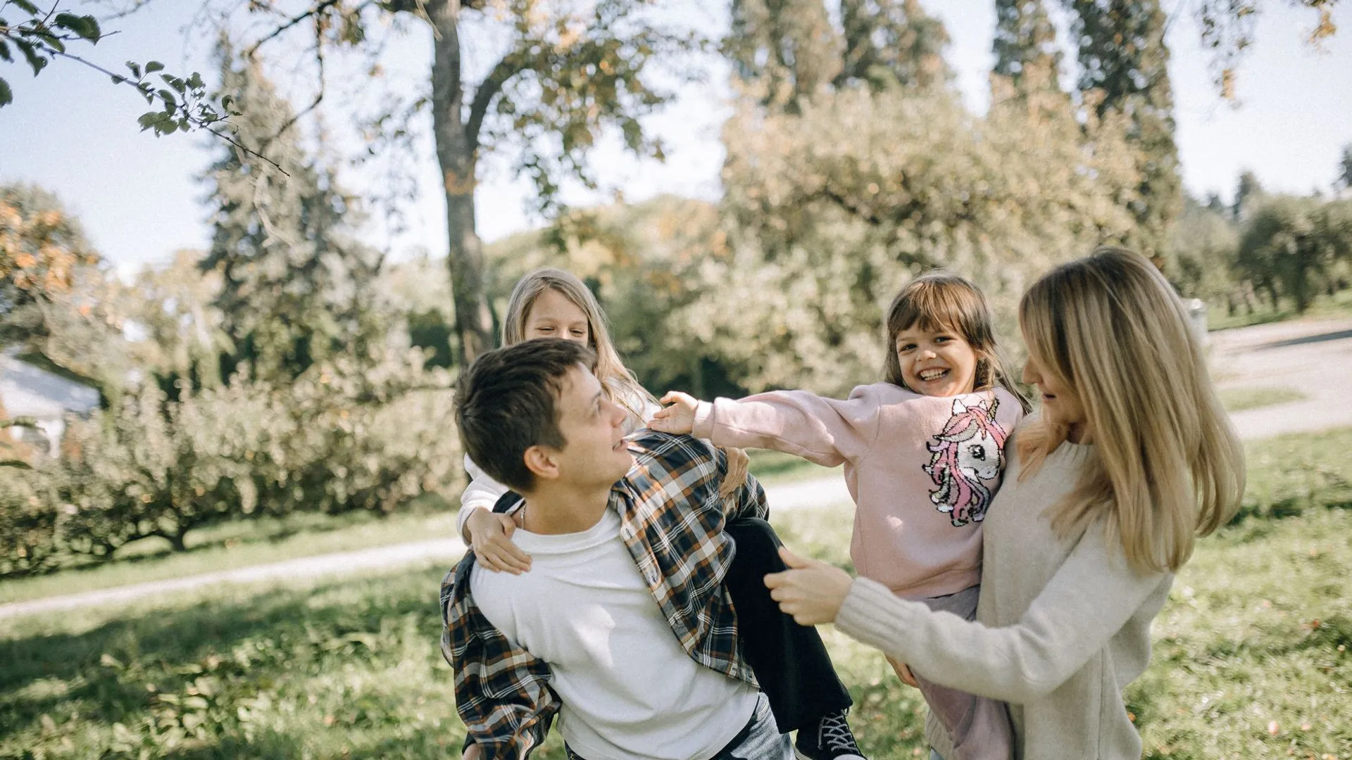 A joyful family spending quality time together in a green park on a sunny day.